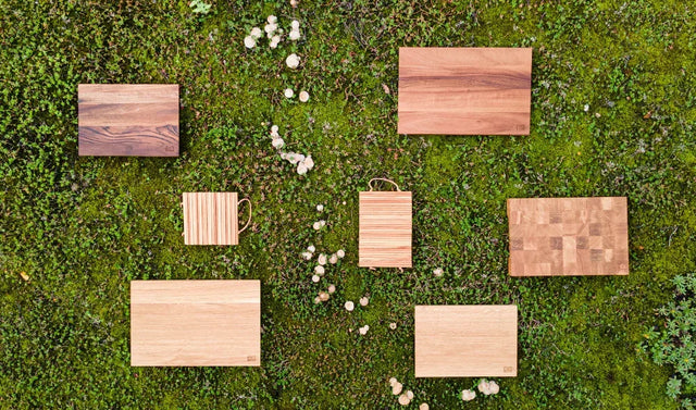 Sustainable wooden cutting boards on green moss, eco-friendly & stylish for any kitchen