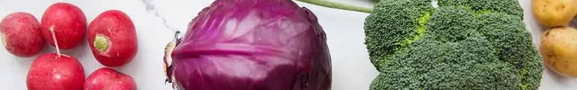 Fresh vegetables like tomatoes, broccoli, and bell peppers on white marble – ideal for sustainable cooking